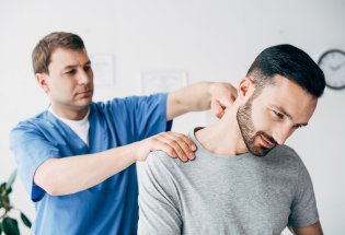 Fysioterapeut behandler nakken til en mann