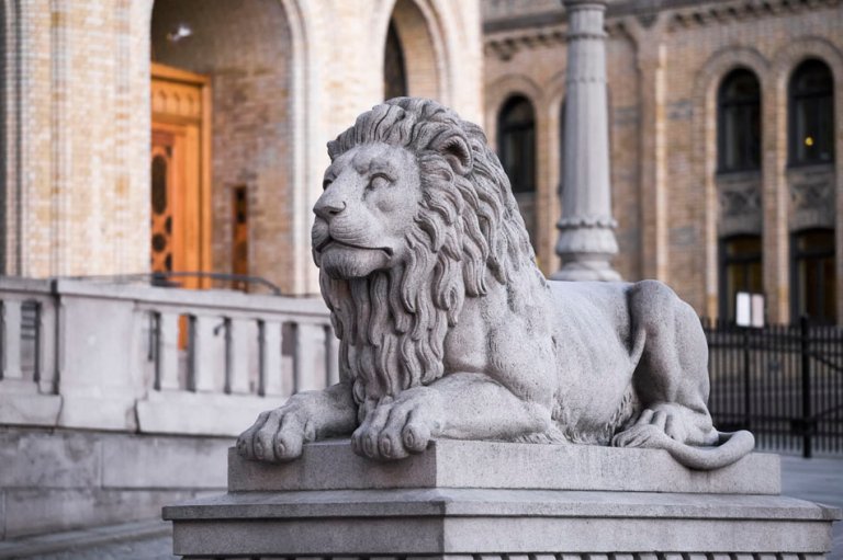 Foto av steinskulptur av løven foran Stortinget